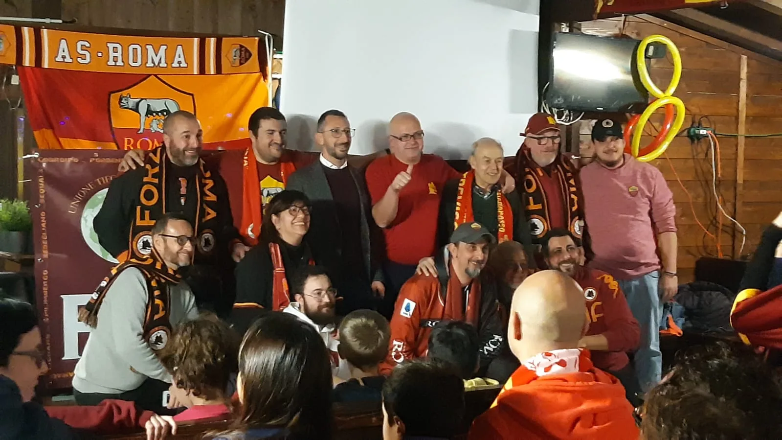 I soci del Roma Club Treviso in sede, davanti alla bandiera dell’AS Roma